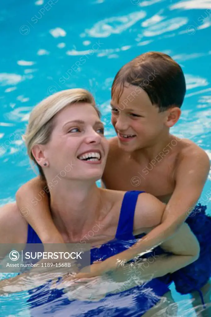 Mid adult woman with her son in a swimming pool