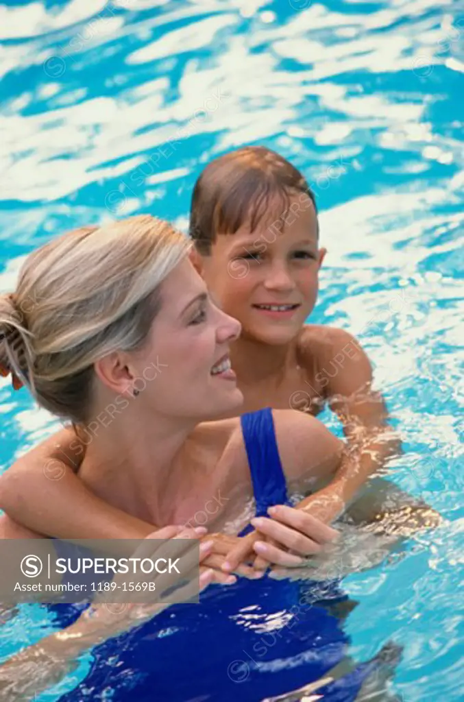 Mid adult woman with her son in a swimming pool