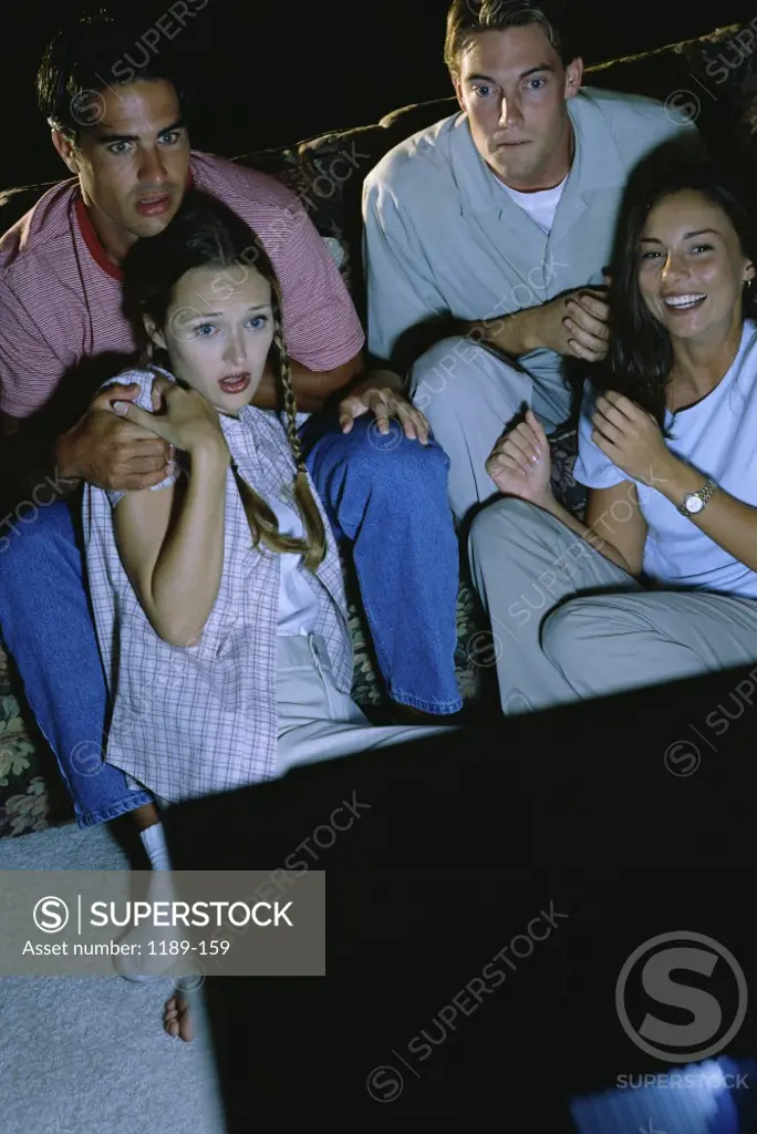 Two young couples watching television