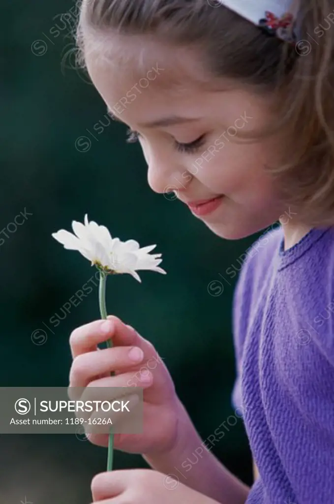 Side profile of a girl holding a flower