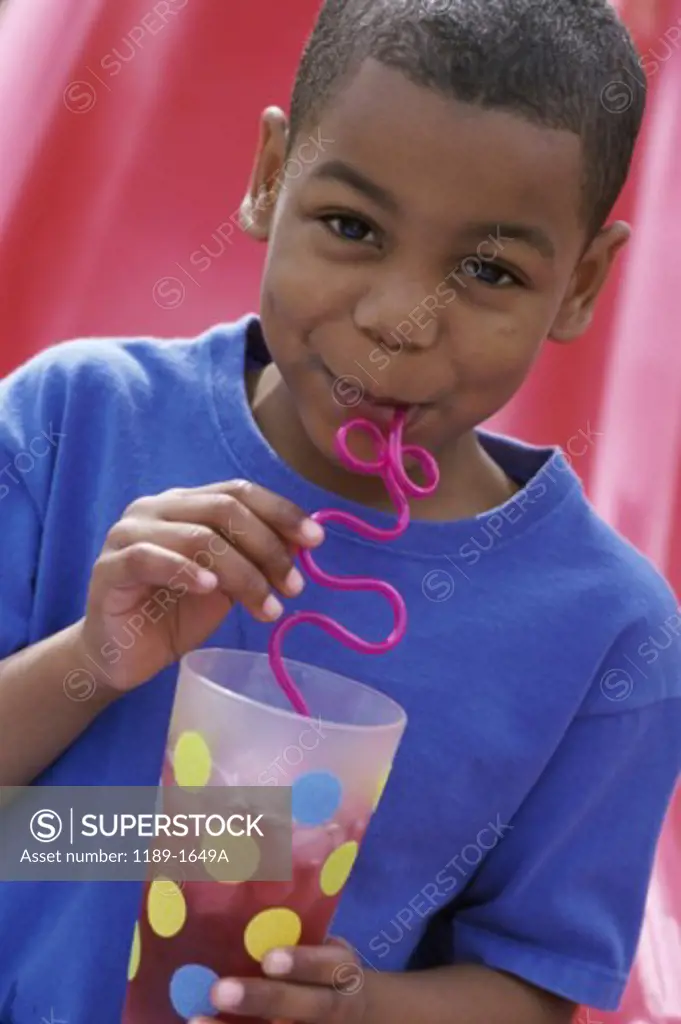 Portrait of a boy drinking with a straw