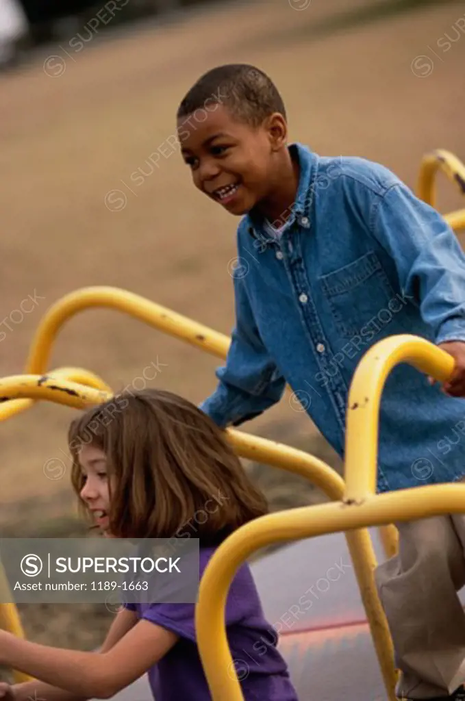 High angle view of a boy and girl playing on a merry-go-round