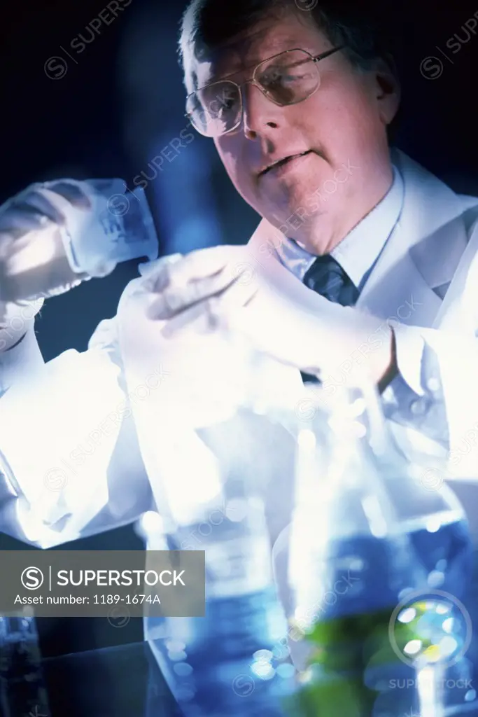 Male scientist pouring chemicals in a laboratory