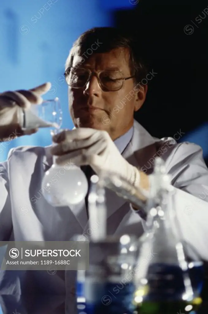 Male scientist pouring chemicals in a laboratory