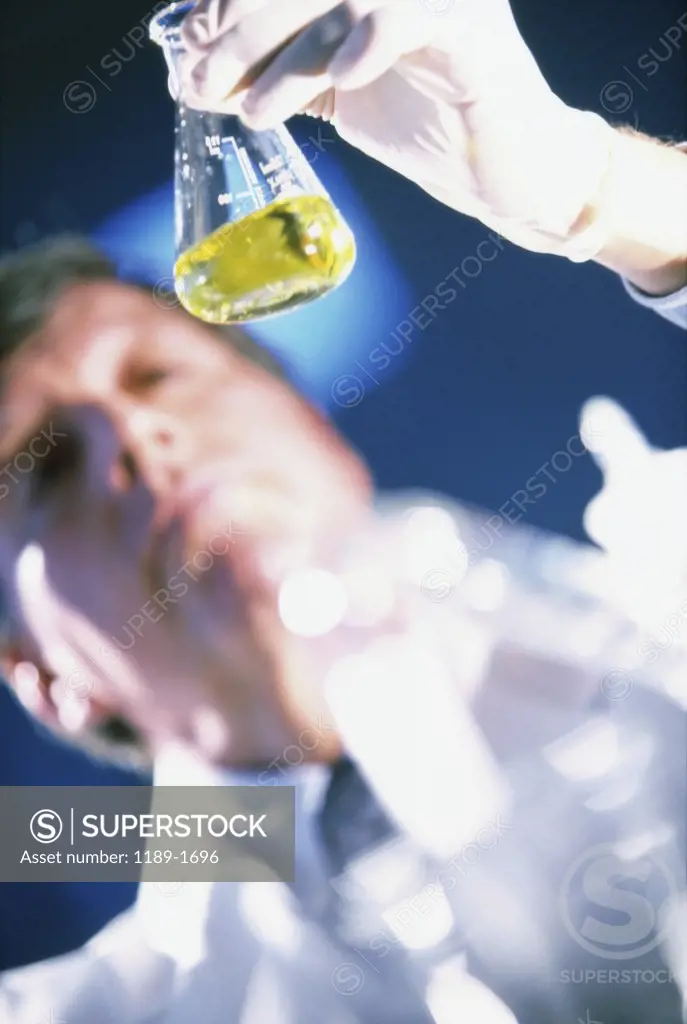 Male scientist looking at a flask in a laboratory