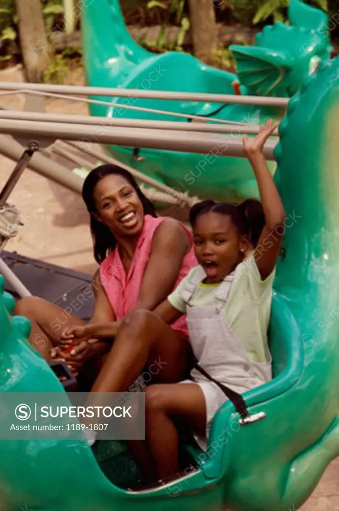 High angle view of a mother and daughter riding an amusement park ride