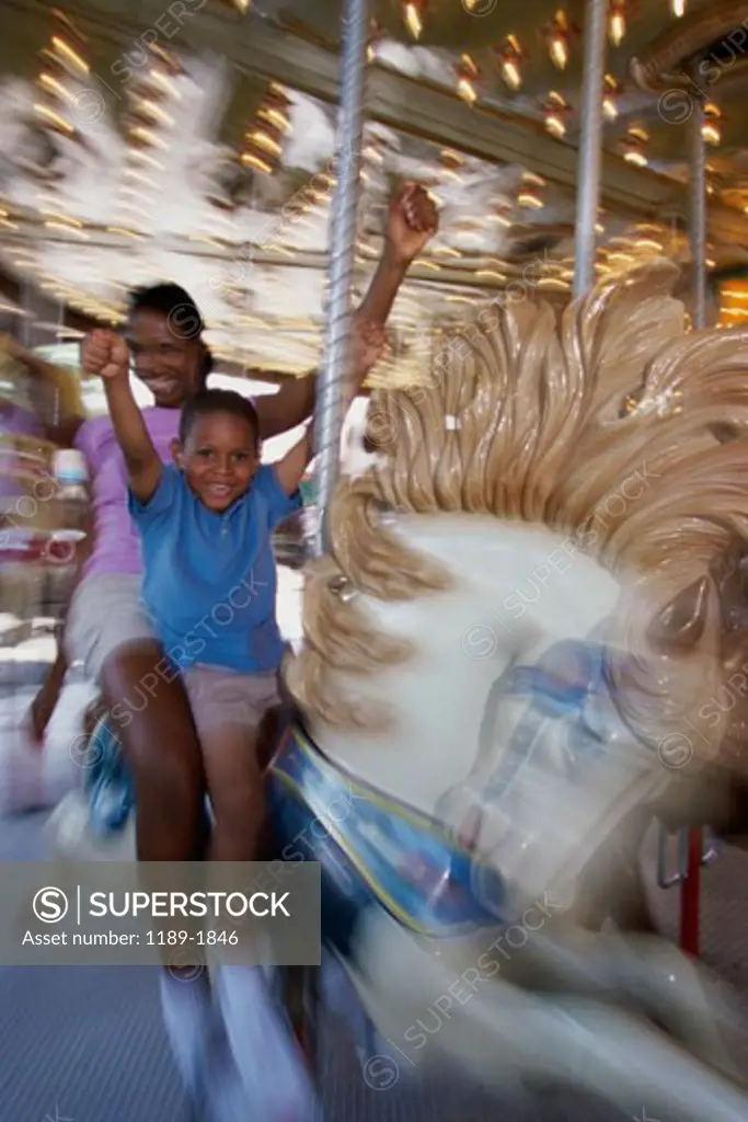 Mother and son riding on a carousel horse