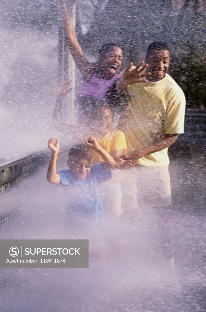 Parents with their son and daughter playing in water