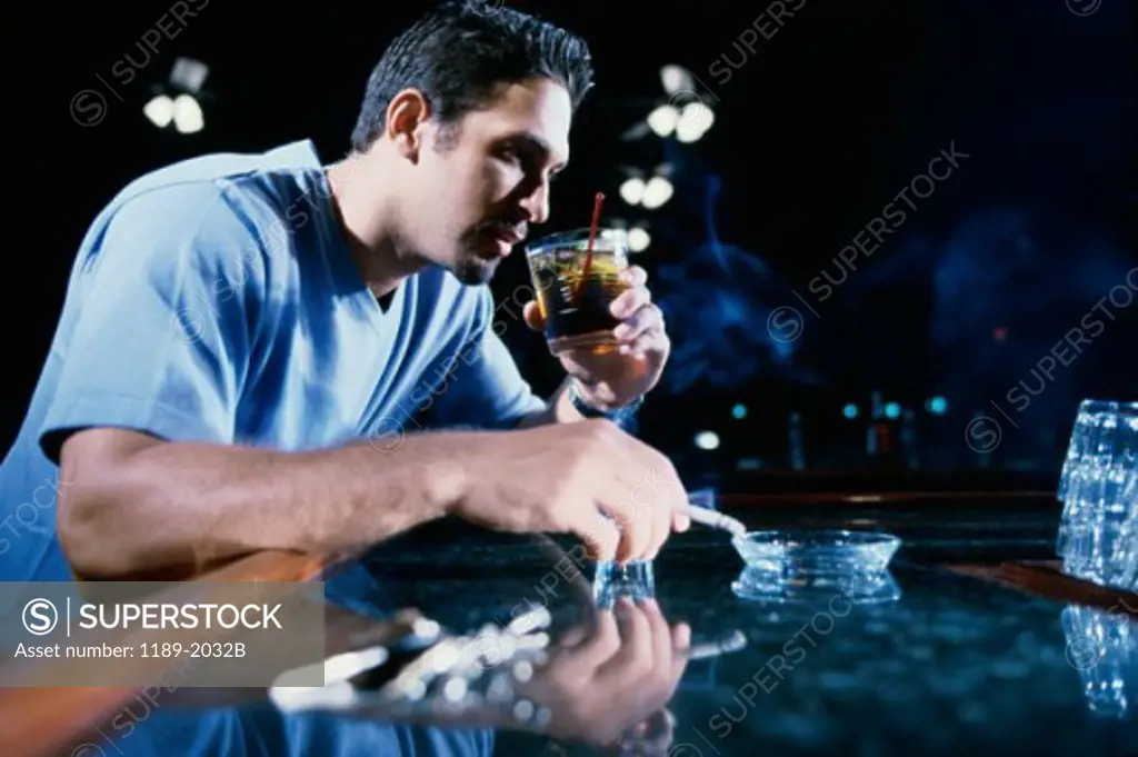 Young man smoking a cigarette and drinking alcohol