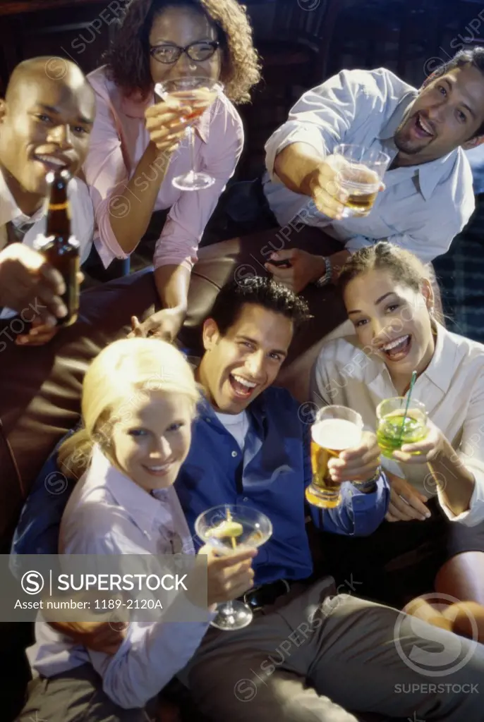 Portrait of a group of young people toasting in a bar