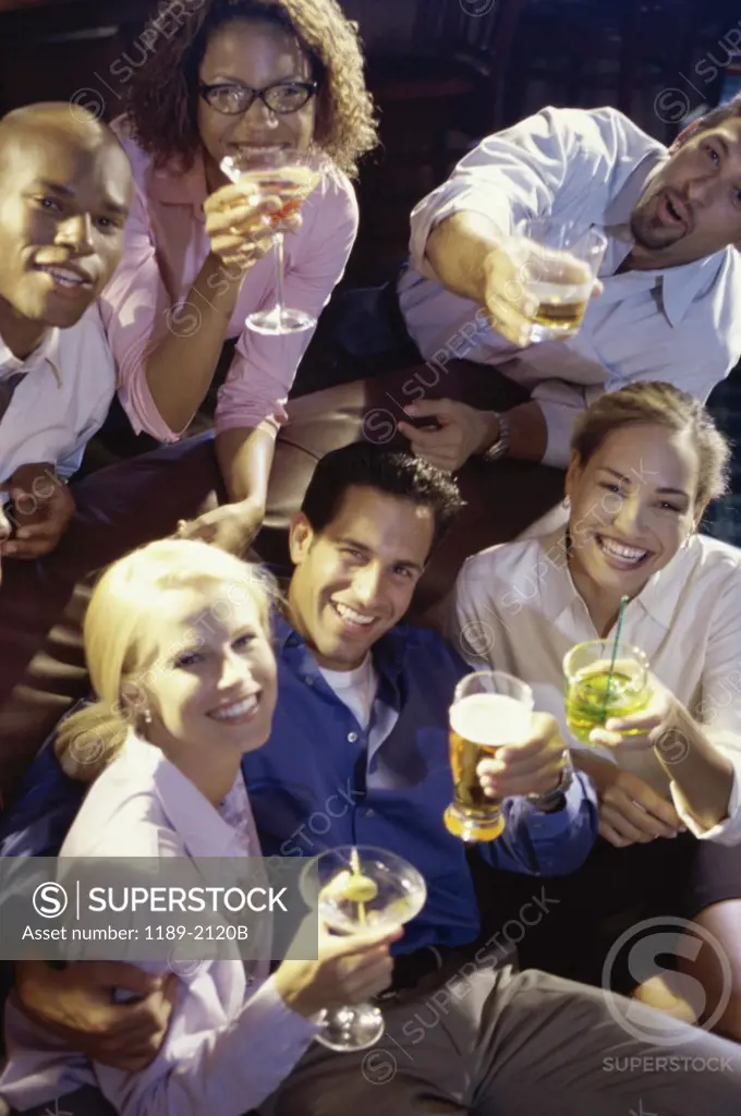 Portrait of a group of young people toasting in a bar