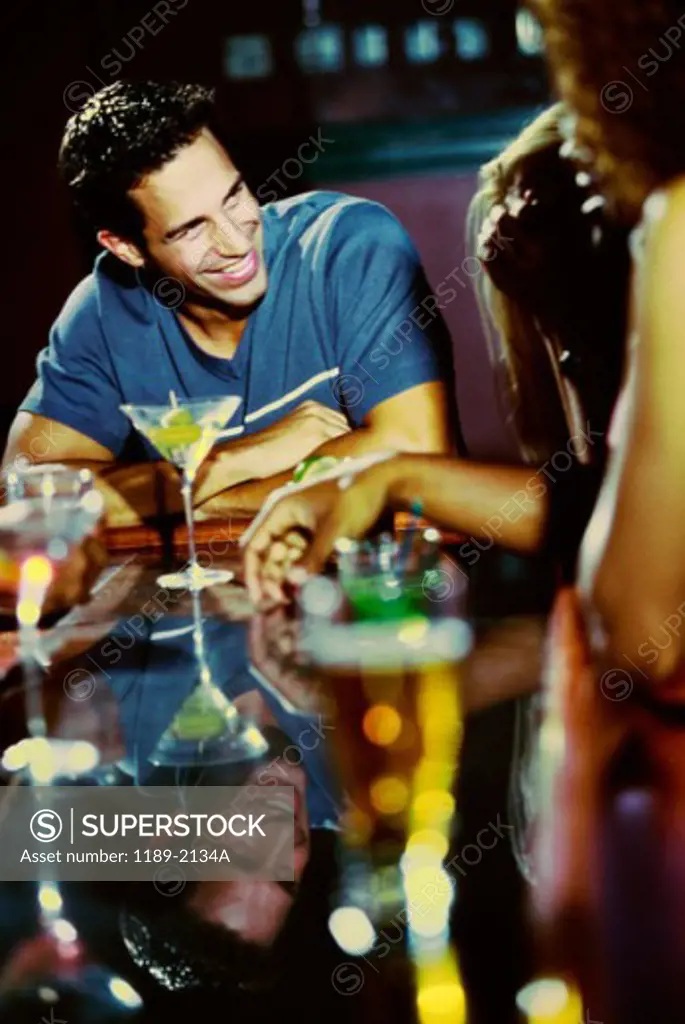 Young man sitting at a bar smiling