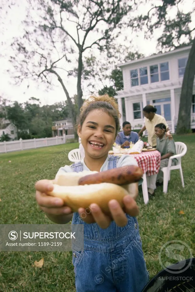 Portrait of a girl offering a hot dog