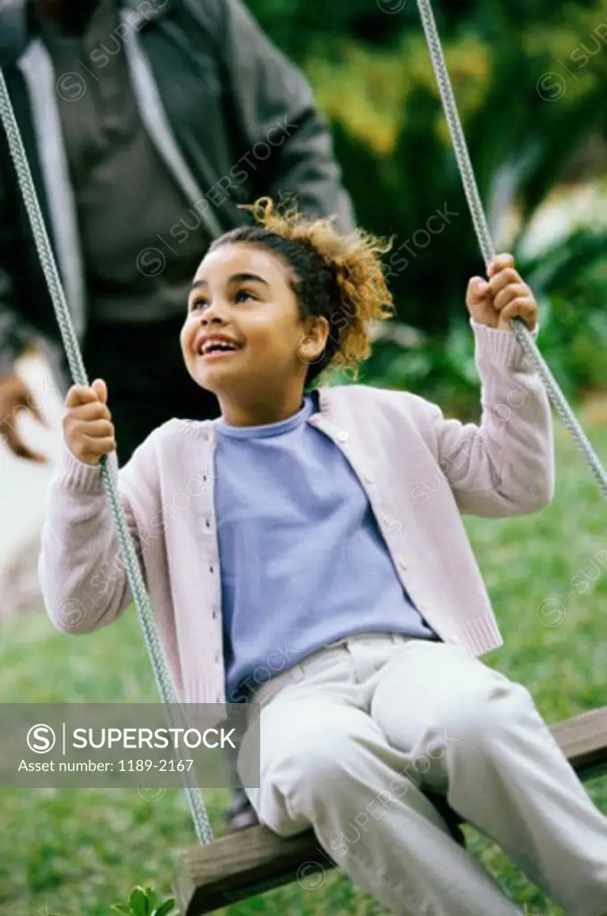 Close-up of a girl swinging on a swing