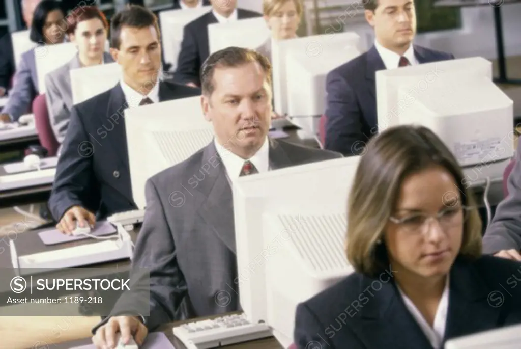 Group of business executives in front of computer monitors
