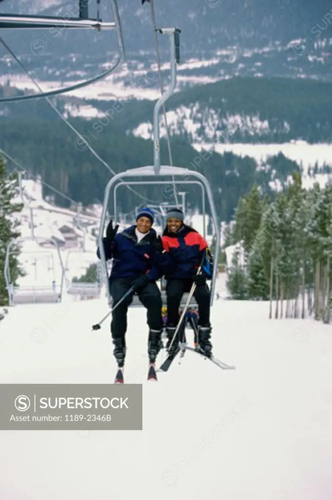 Portrait of a young couple sitting on a ski lift