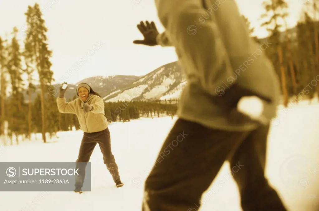Young couple throwing snowballs