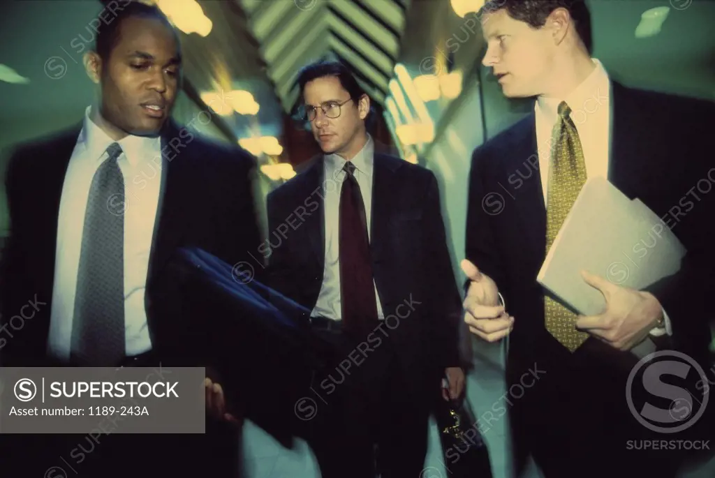 Three businessmen walking in a corridor
