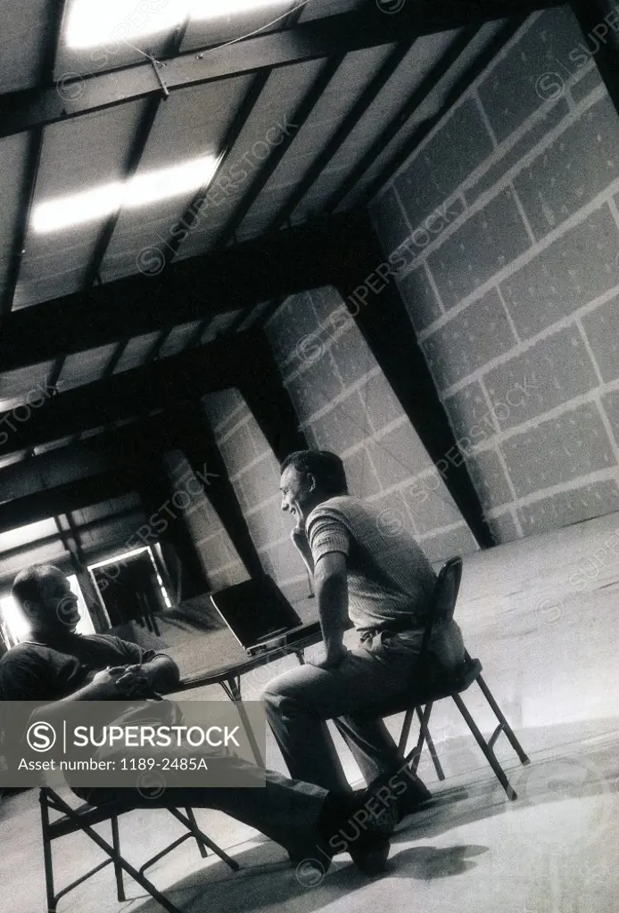 Two businessmen sitting in a warehouse