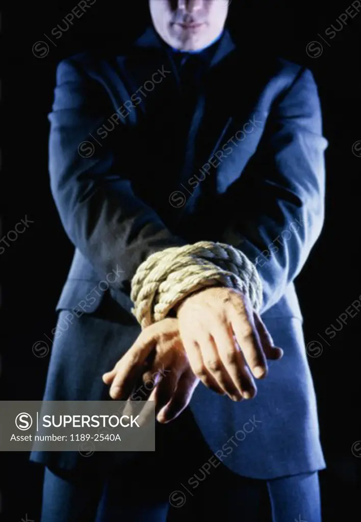 Businessman's hands tied together with a rope