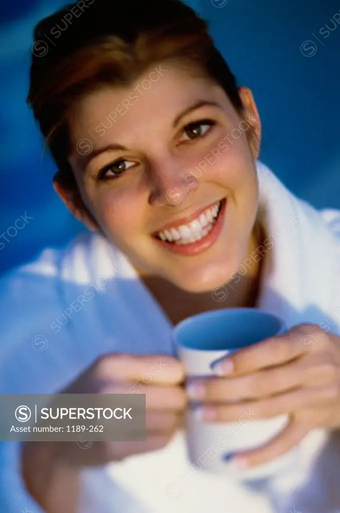 Portrait of a young woman holding a cup of coffee