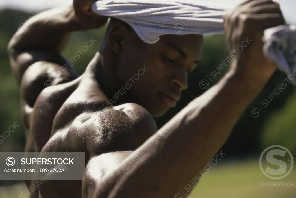 Side profile of a young man flexing his muscles