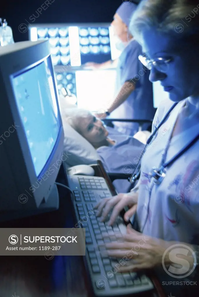 Side profile of a female nurse operating a computer