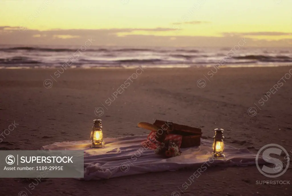 Two lanterns and a sheet of cloth on the beach