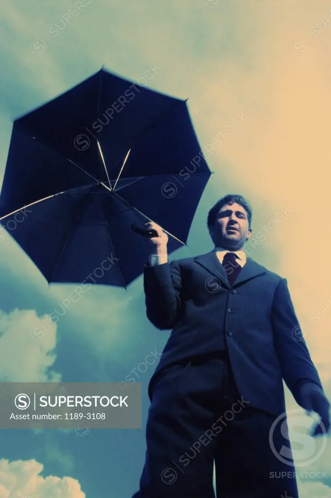 Low angle view of a businessman holding an umbrella