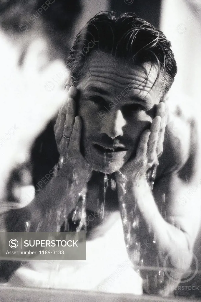 Portrait of a mid adult man washing his face