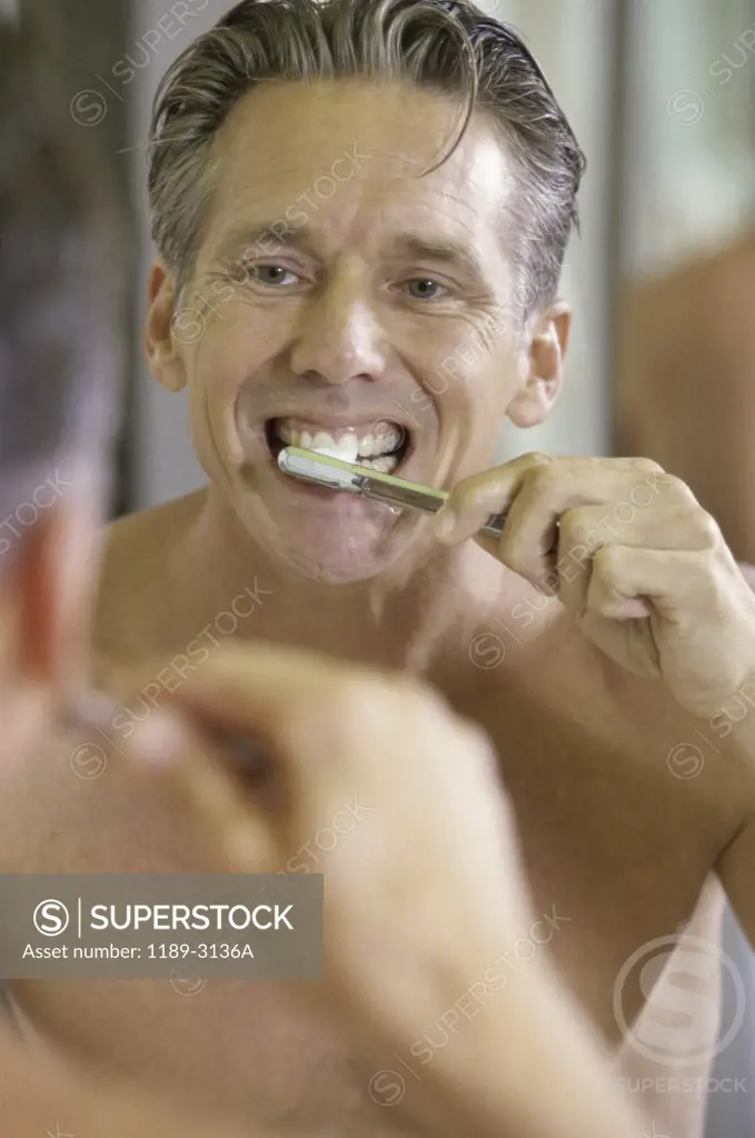 Mid adult man brushing his teeth