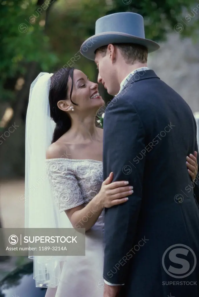Side profile of a newlywed couple embracing each other