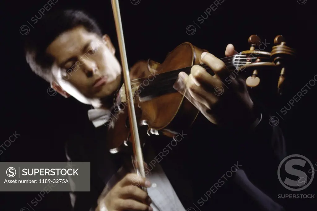 Low angle view of a young man playing the violin