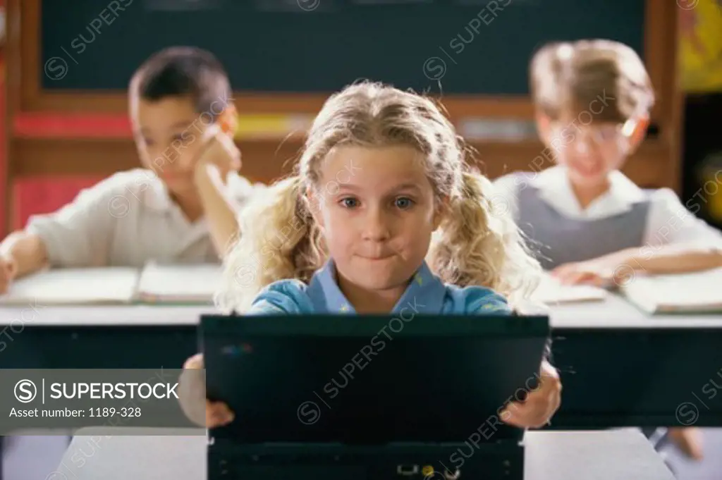 Girl using a laptop in a classroom