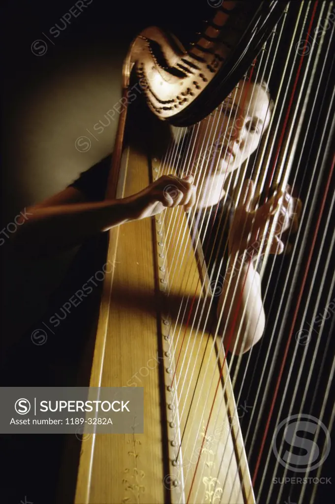 Young woman playing the harp