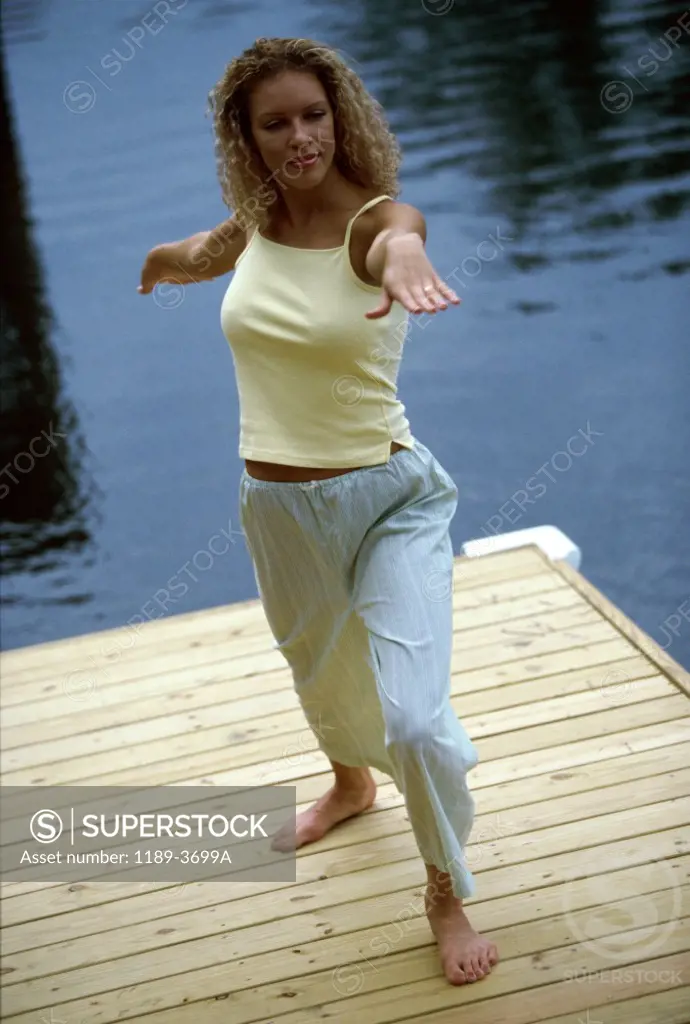 High angle view of a young woman exercising on a dock