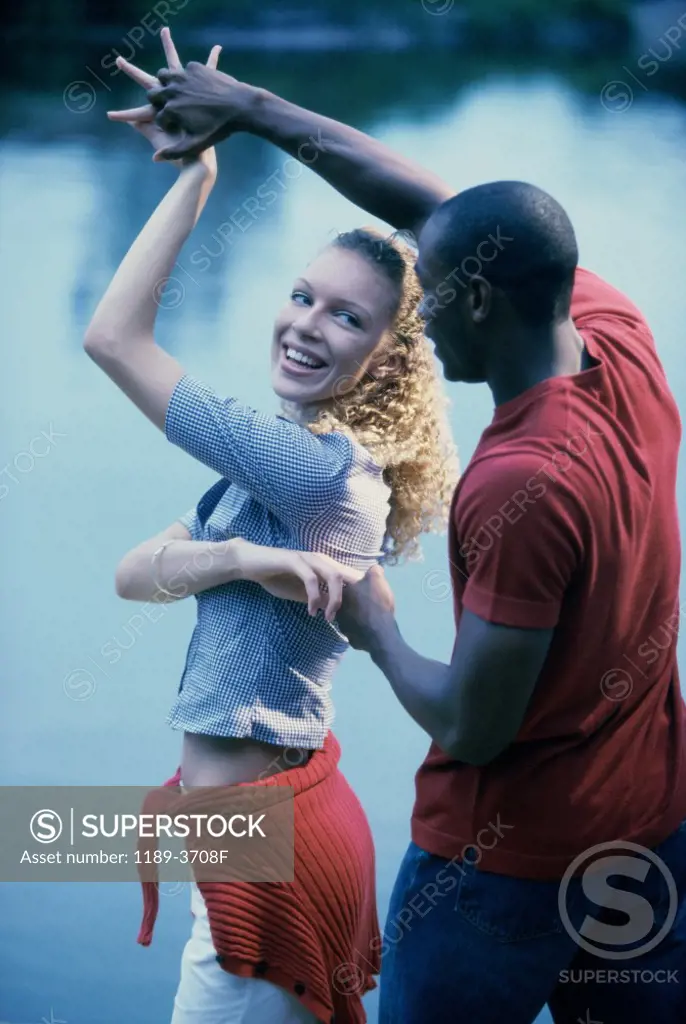 Young couple dancing by a lake