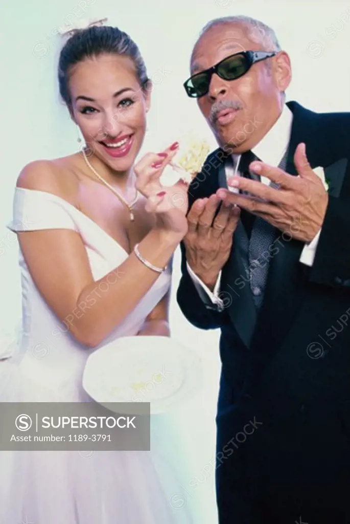 Portrait of a bride feeding cake to her groom