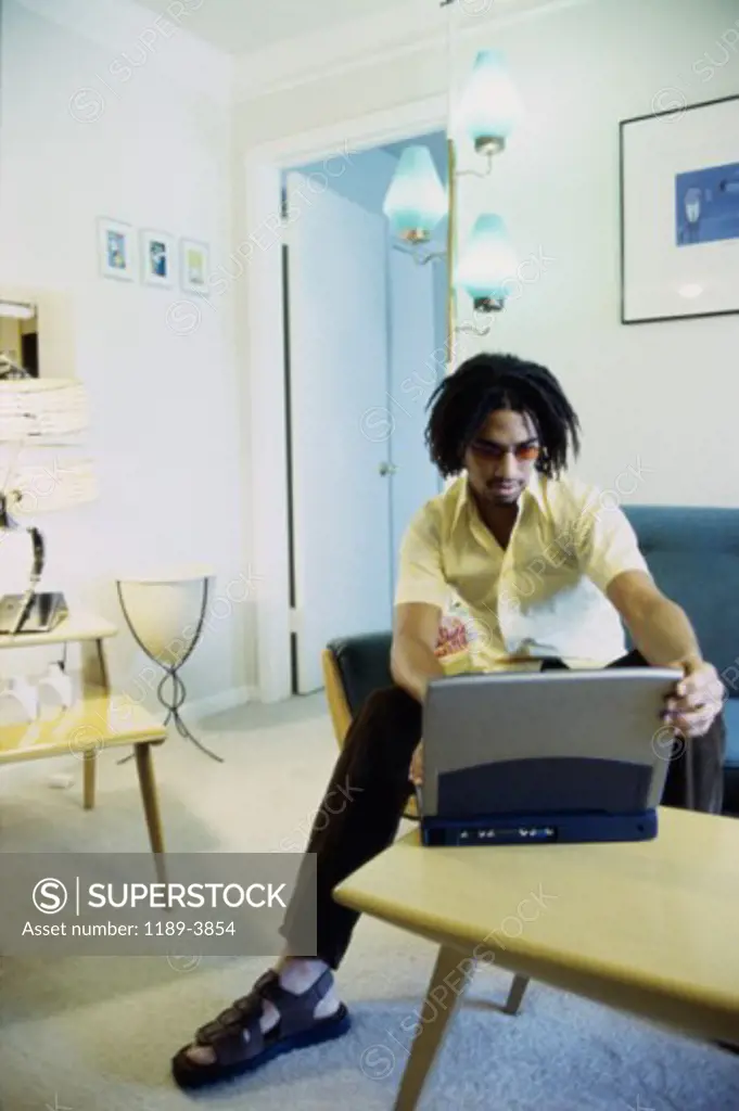 Young man sitting on a couch using a laptop