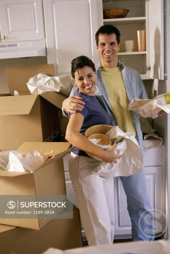 Portrait of a young couple unpacking in their new house