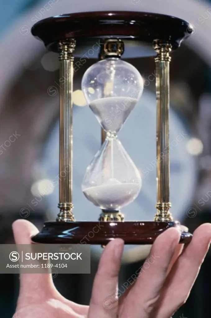 Close-up of a person holding an hourglass