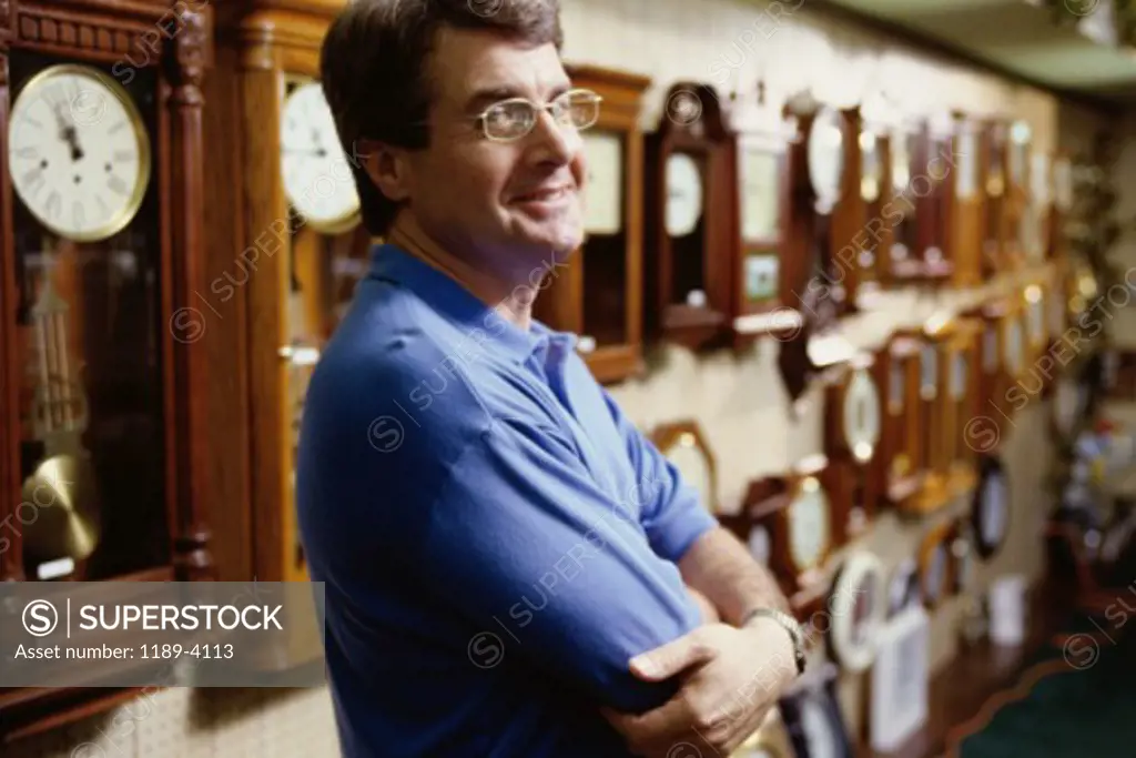 Side profile of a mature man standing in a store with his arms folded