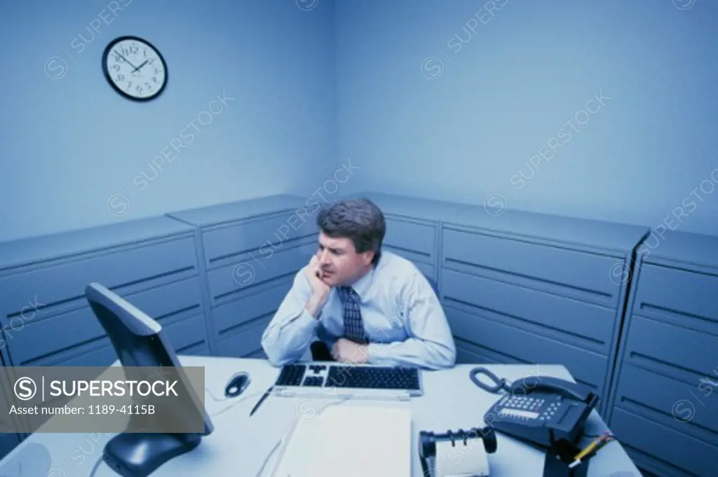 High angle view of a businessman sitting in front of a computer monitor