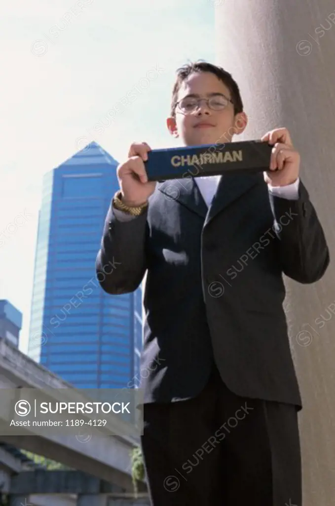 Portrait of a boy holding a placard with the word chairman