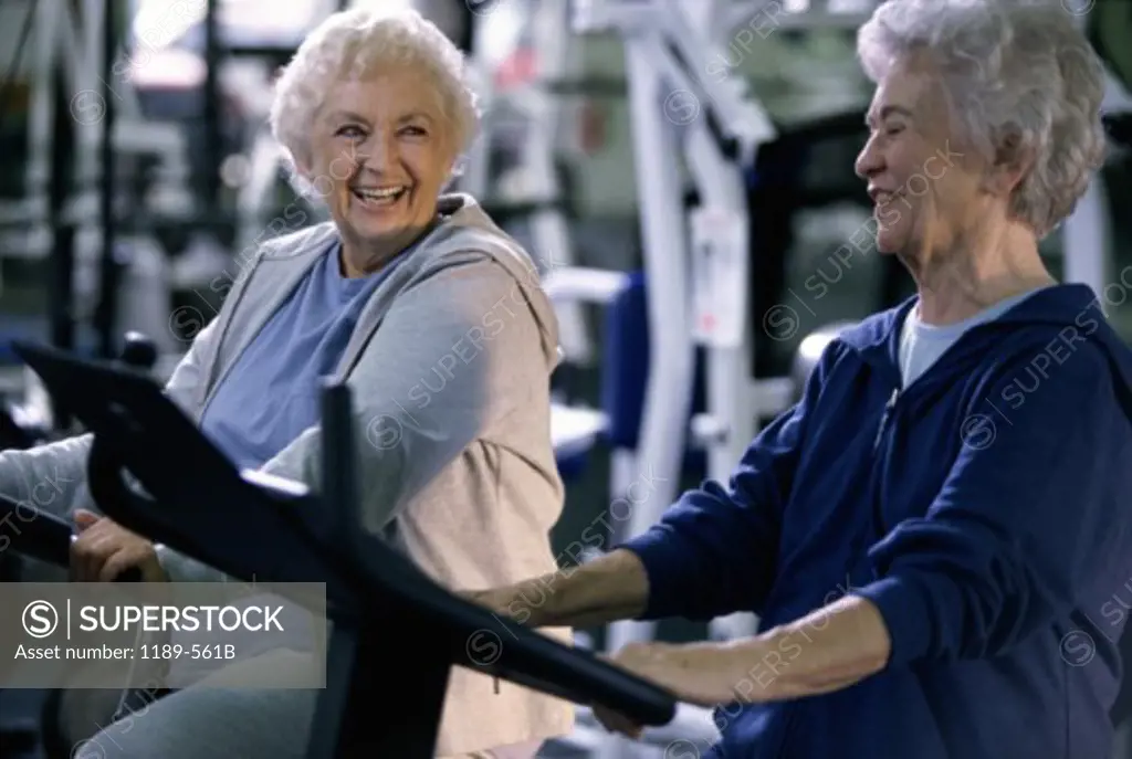 Two senior women exercising in a health club