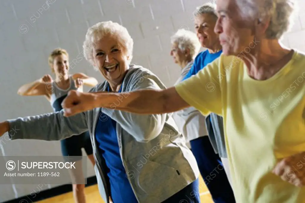 Young woman teaching a group of senior women aerobics