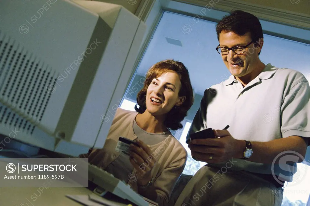 Mid adult couple using a computer