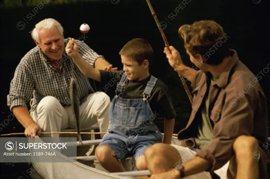 Grandfather sitting in a boat with his son and grandson