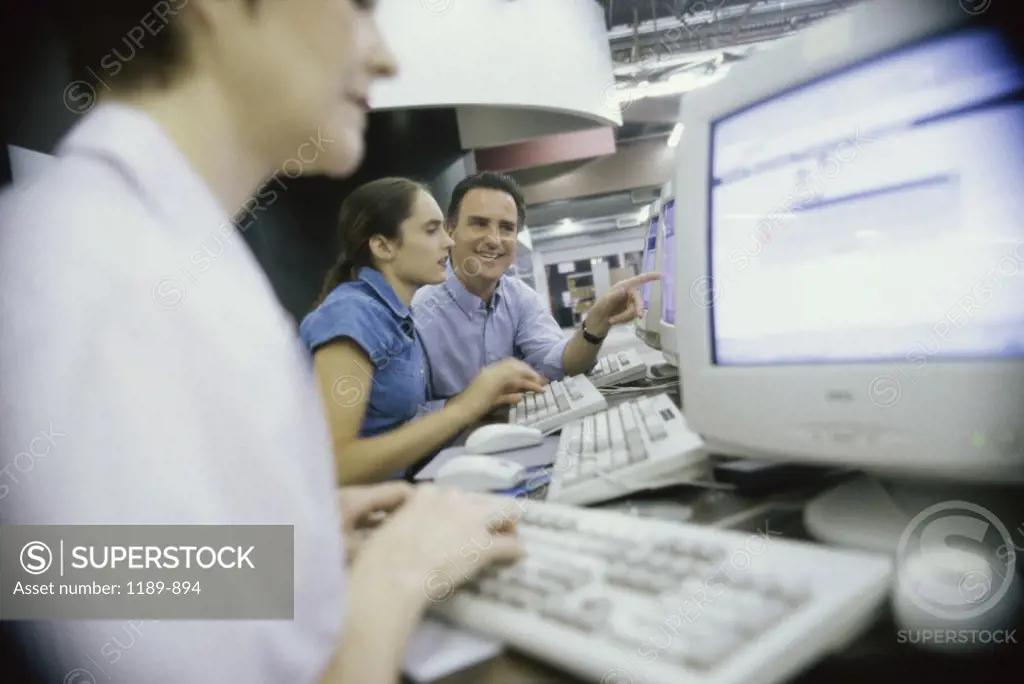 Male teacher and his students in front of a computer