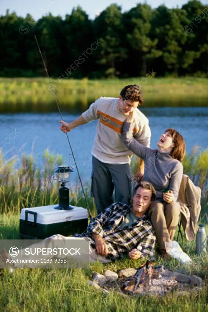 Mature couple with their son near a campfire